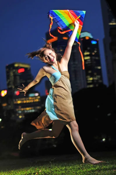 Asiatisk kinesisk flicka som leker i skymningen med en drake — Stockfoto