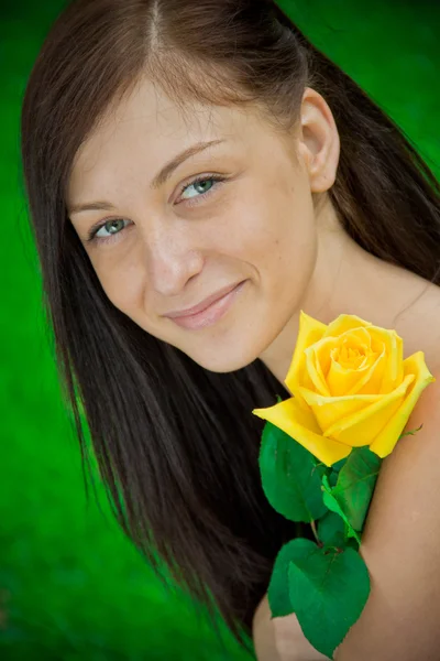 Красивая улыбающаяся женщина с цветком — стоковое фото