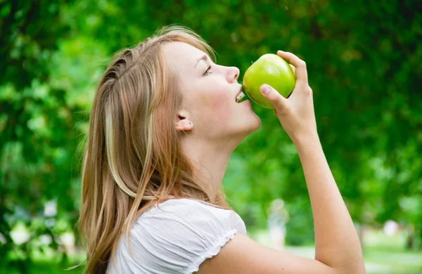 Menina bonita com as maçãs na grama — Fotografia de Stock