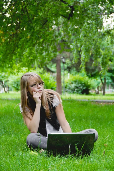 美丽的女孩在公园与便携式计算机 — 图库照片