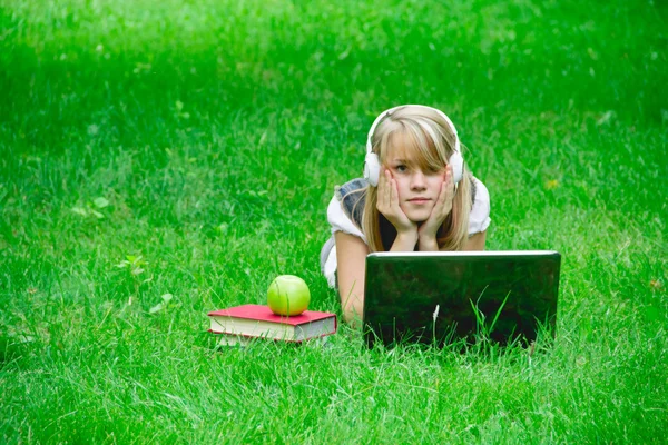 Beautiful girl listening to music in the park — Stock Photo, Image