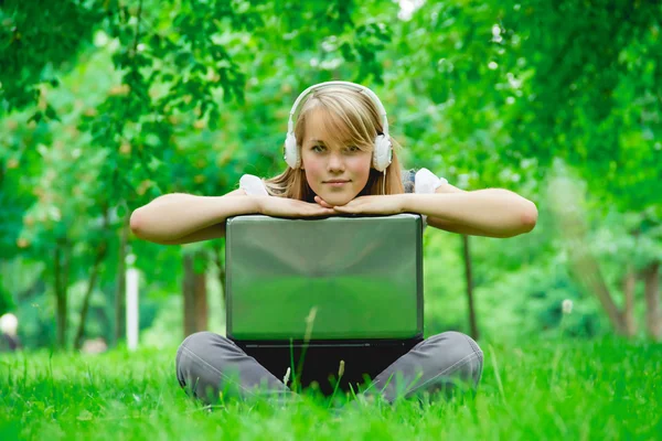 Beautiful girl listening to music in the park — Stock Photo, Image