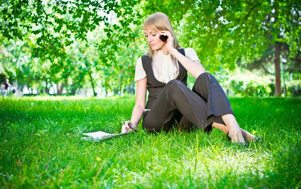 Donna d'affari con telefono sull'erba — Foto Stock