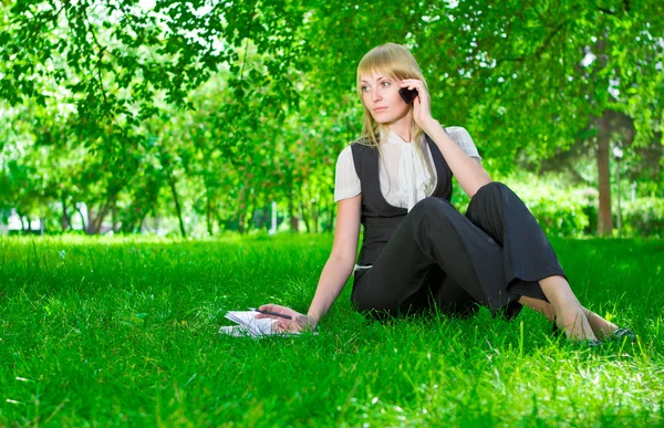 Geschäftsfrau mit Telefon im Gras — Stockfoto