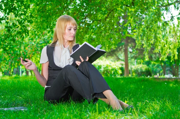 Geschäftsfrau mit Notizbuch im Gras — Stockfoto