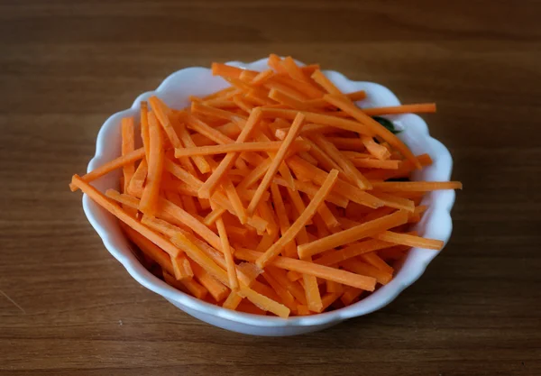 Weißer Teller mit Karottenscheiben liegt auf dem Tisch — Stockfoto