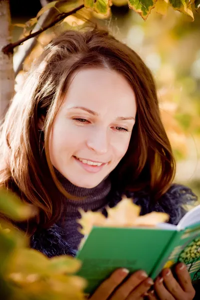 Ung kvinna läsa bok i höst — Stockfoto