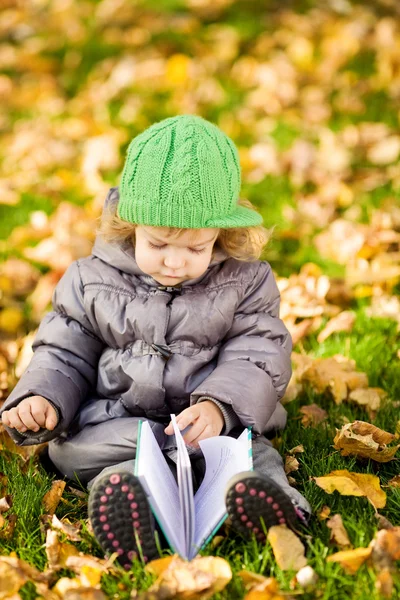 Dziecka, czytanie w parku jesień — Zdjęcie stockowe