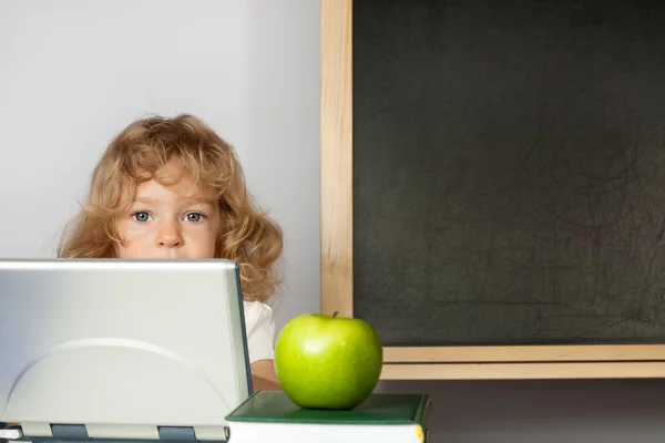 Schoolchild typing on computer in classroom — Stok fotoğraf