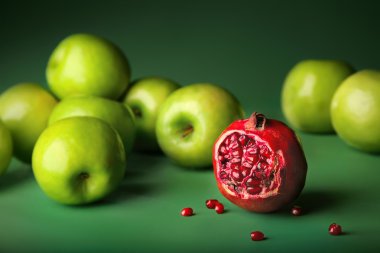 Still-life of pomegranate with green apples clipart