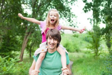 Father and daughter.Young man holding blonde little girl on shou clipart