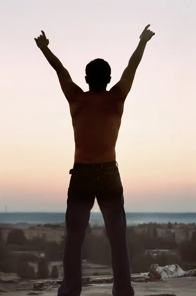 Libertà. Silhouette giovane uomo con le mani sollevate verso l'alto — Foto Stock