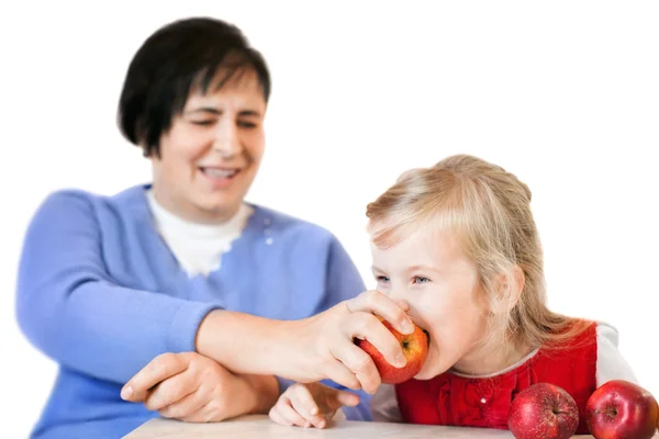Glad mogen kvinna och liten flicka med äpplen isolerad på vit — Stockfoto