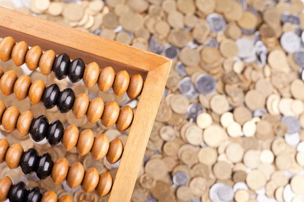 Účetní počítadlo a hromadu mincí — Stock fotografie
