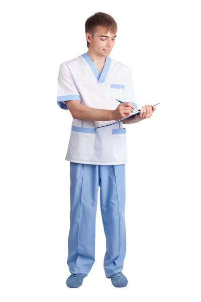 Młody lekarz uśmiechający się wypełnia formularz w schowek isolat — Zdjęcie stockowe