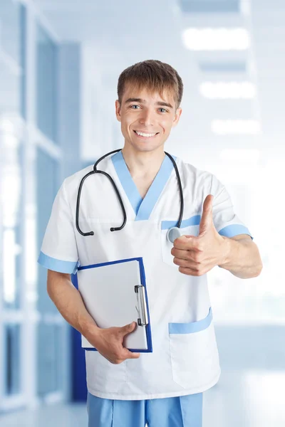 Lächelnder Arzt zeigt Daumen hoch im Krankenhaus — Stockfoto