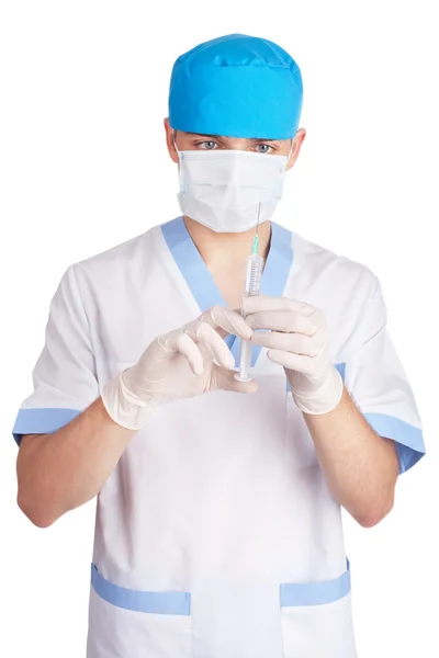 Médico em uma máscara tem controle sobre uma seringa isolada em — Fotografia de Stock