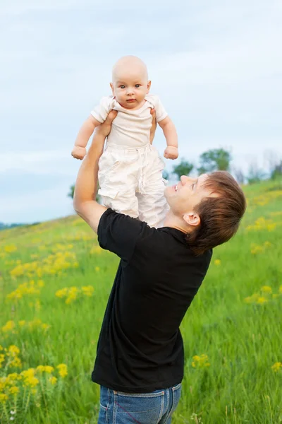 Jovem feliz jogando seu menino — Fotografia de Stock