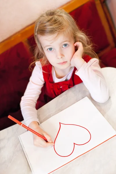 Mała dziewczynka rysuje serce. Walentynki — Zdjęcie stockowe