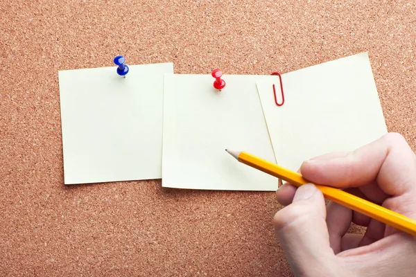 Escritura a mano humana con lápiz en tres papeles de notas sobre jabalí de corcho —  Fotos de Stock