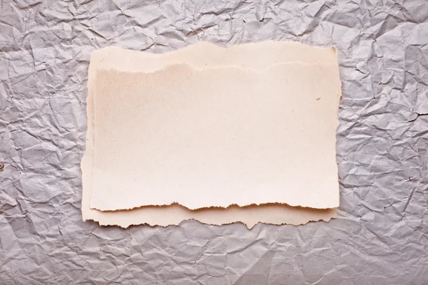 Ripped piece of paper on old crushed paper background. vintage r — Stock Photo, Image