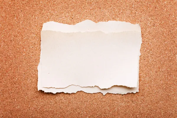 Strappato pezzo di carta su sfondo cartone di sughero — Foto Stock