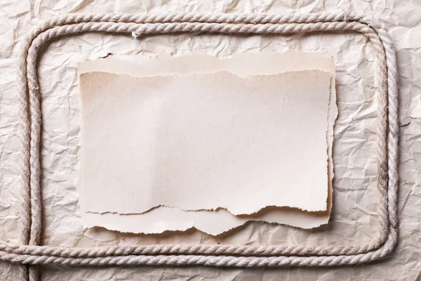 Ripped piece of paper and rope on old crushed paper background. — Stock Photo, Image
