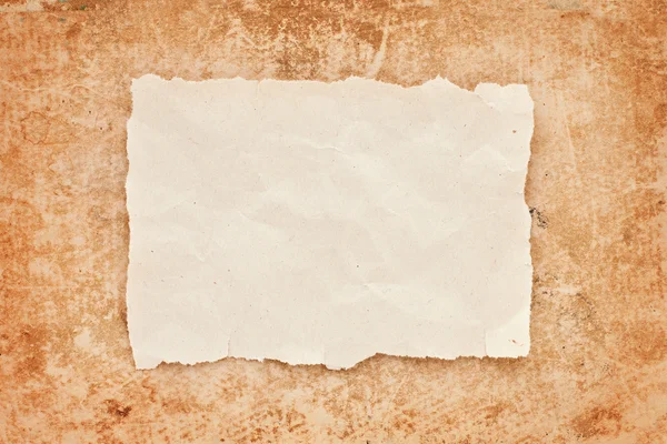 Ripped piece of old paper on grunge paper background. vintage re — Stock Photo, Image