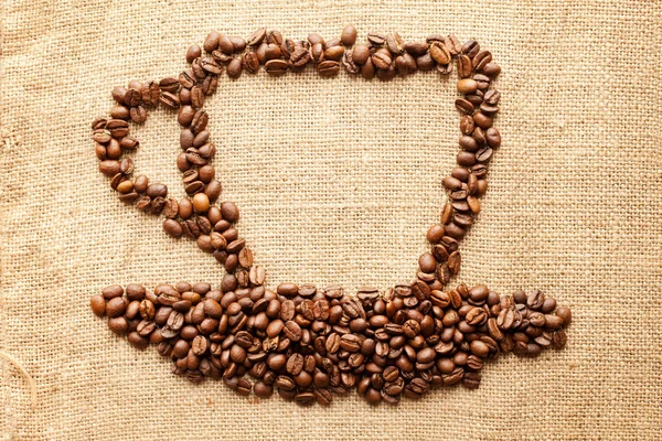 Kopp kaffe från liktornar på tyg textur bakgrund — Stockfoto