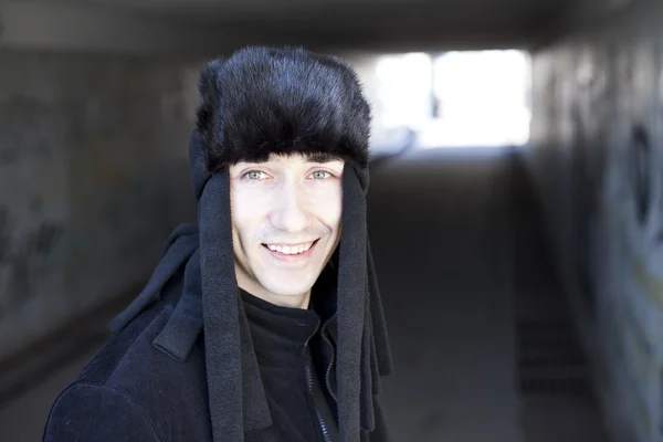 Uśmiechający się młody człowiek w tunelu metra — Zdjęcie stockowe