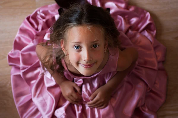 Smilende liten jente i rosa kjole – stockfoto