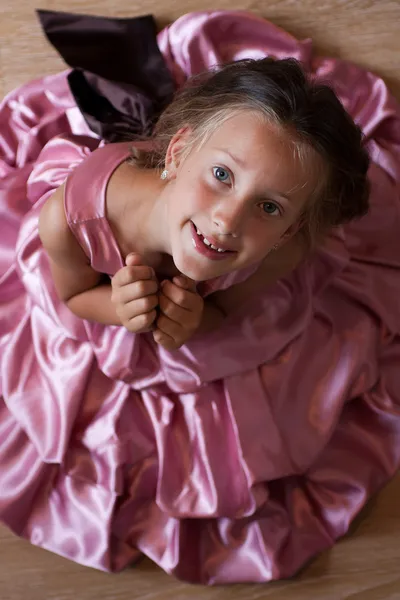 Pembe elbiseli küçük kız gülümseyerek — Stok fotoğraf