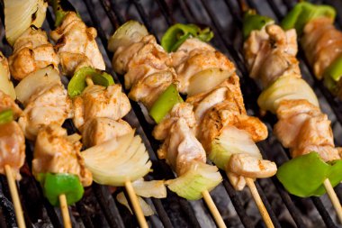 Meat and vegetables on barbecue sticks - closeup clipart