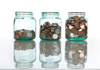 Glass jars with coins - savings concept clipart