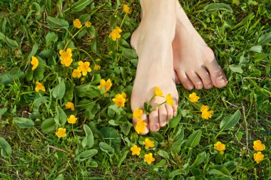 Woman resting her feet in the fresh spring vegetation