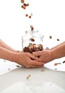 Elderly hands holding jar catching falling coins clipart