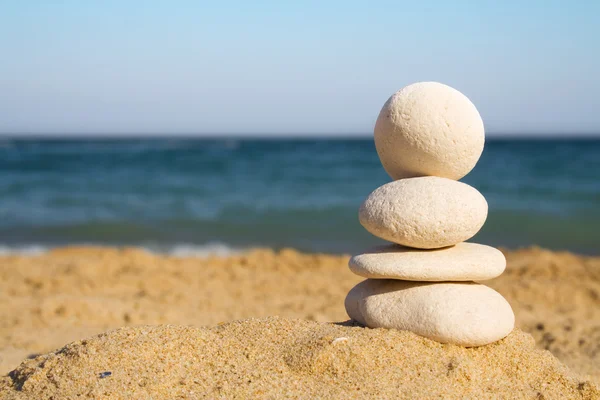 stock image Stacked white pebbles on the beach