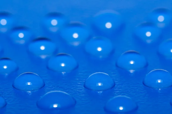Водяні краплі на блакитній поверхні — стокове фото