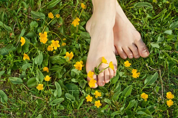 Mujer descansando sus pies en la vegetación fresca de primavera —  Fotos de Stock