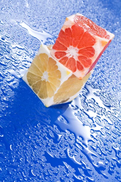 Cubos de citrinos na superfície molhada — Fotografia de Stock