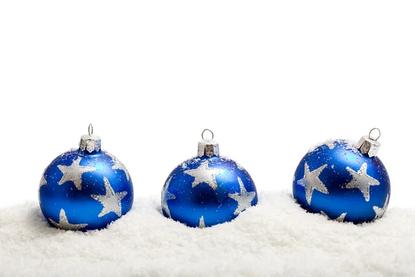Три сині різдвяні кульки на снігу - ізольовані — стокове фото