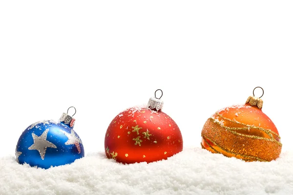 Kleurrijke kerstballen in de sneeuw — Stockfoto
