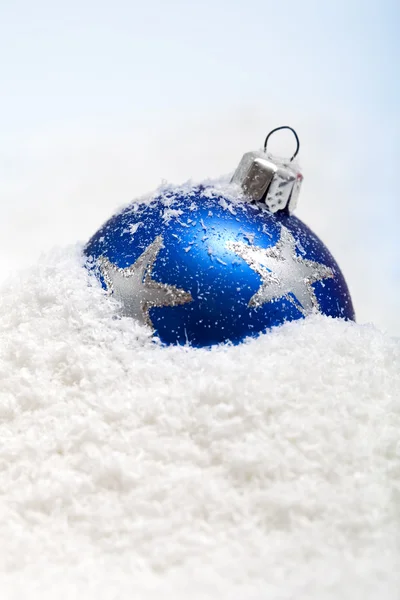 Голубая рождественская безделушка в снегу — стоковое фото