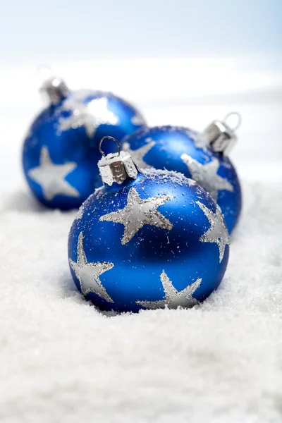 雪の中で 3 つの青いクリスマス ボール — ストック写真