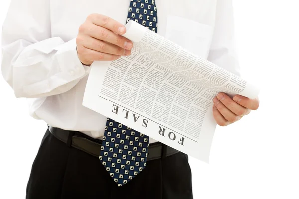 Affärsman läsa papper med försäljning annonser — Stockfoto