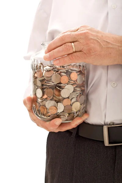 Manos mayores sosteniendo frasco con un montón de monedas — Foto de Stock