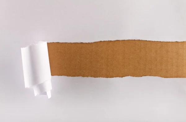 Roztržené balicí papír nad hnědá lepenka — Stock fotografie