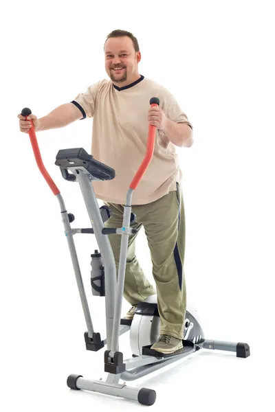 Hombre haciendo ejercicio sobre un entrenador elíptico —  Fotos de Stock