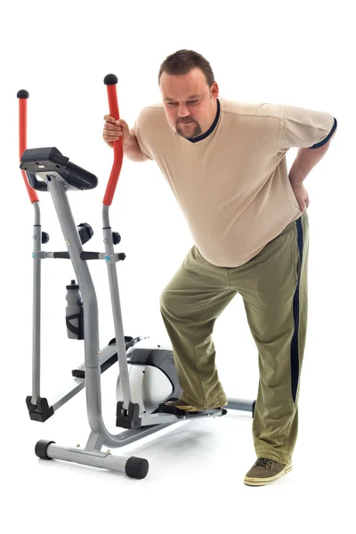 Man with back ache near a training device — Stock Photo, Image