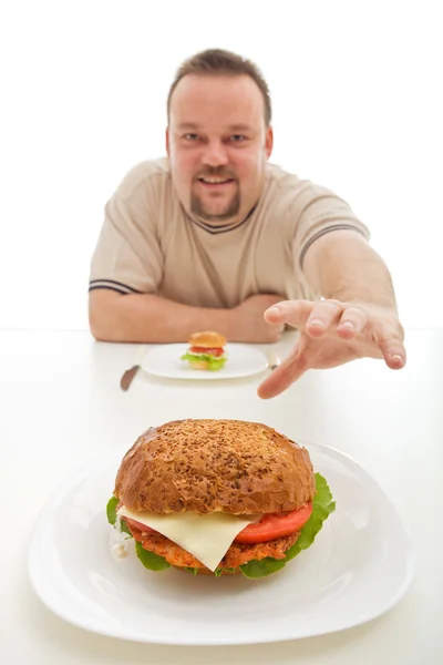 더 큰 것에 도달 하는 작은 햄버거를 가진 남자 — 스톡 사진